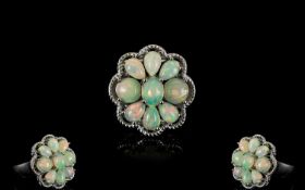 Opal Cluster Ring, comprising six pear cut and two round cut opal cabochons, closely set around an