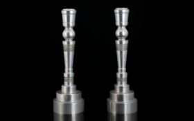 A Pair Of Turned Metal Art Deco Style Candlesticks Each of typical form,