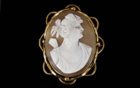 Antique Cameo Brooch Shell cameo of large, oval form in gold tone mount with scalloped edge.