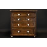 A Small Four Drawer Graduating Beechwood Chest The drawers finished with white ceramic handles,