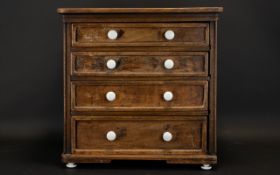 A Small Four Drawer Graduating Beechwood Chest The drawers finished with white ceramic handles,