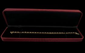 A 14 ct Diamond Tennis Bracelet Set with alternating rubies and brilliant cut diamonds, length 7 1/4