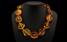 Reconstituted Freeform Amber Coloured Necklace comprising thirteen polished amber beads of organic