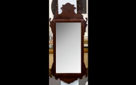 A Reproduction Georgian Style Bevelled Glass Mirror In shaped Mahogany finish frame. 20 x 43.