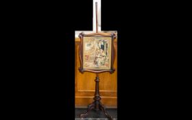 A Victorian Pole Screen Shaped mahogany screen with wool work sampler, raised on tripod base, height