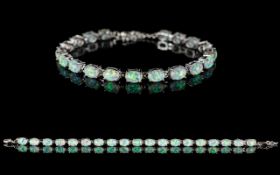 A Contemporary Silver And Opal Set Tennis Bracelet - Comprising 19 Oval Cabochon Opals.