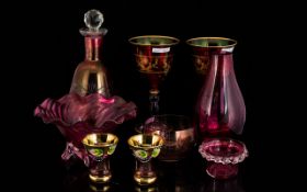 A Collection Of Cranberry Coloured Glass To include globular form decanter, two gilt trim goblets,