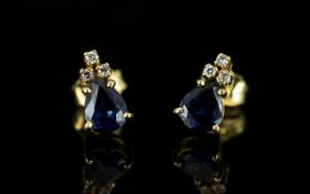A Pair Of 18ct Gold Sapphire And Diamond Earrings Comprising three round cut diamonds above a pear