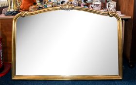 A Large Over Mantle Gilt Frame Mirror - of shaped form with bevelled glass and scroll / shell