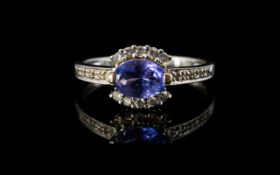 18ct White Gold Tanzanite And Diamond Dress Ring Central oval tanzanite surrounded by round cut