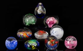 A Collection Of Coloured Glass Paperweights Ten in total to include encapsulated flower,