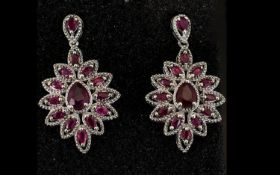 Ruby Ovoid Cluster Drop Earrings, each earring having a pear cut ruby surrounded by marquise cut