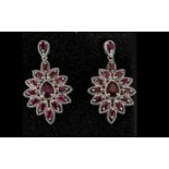 Ruby Ovoid Cluster Drop Earrings, each earring having a pear cut ruby surrounded by marquise cut