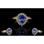 9ct Gold Sapphire And Diamond Dress Ring Pear shaped central sapphire surrounded by round cut