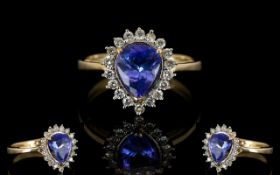 9ct Gold Sapphire And Diamond Dress Ring Pear shaped central sapphire surrounded by round cut