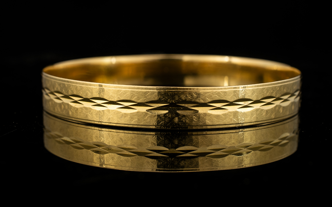 An 18ct Gold Italian Bangle Yellow gold bangle with textured finish and etched diamond pattern.