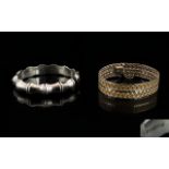 A Silver Hinged Bangle Of bamboo form with attached safety chain,