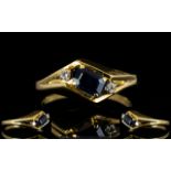 14ct Gold Sapphire And Diamond Dress Ring Set with central step cut sapphire between two round cut
