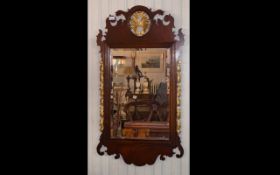 A Reproduction Georgian Mirror - housed in wood frame with curlicue edge detail and gilt shell trim.