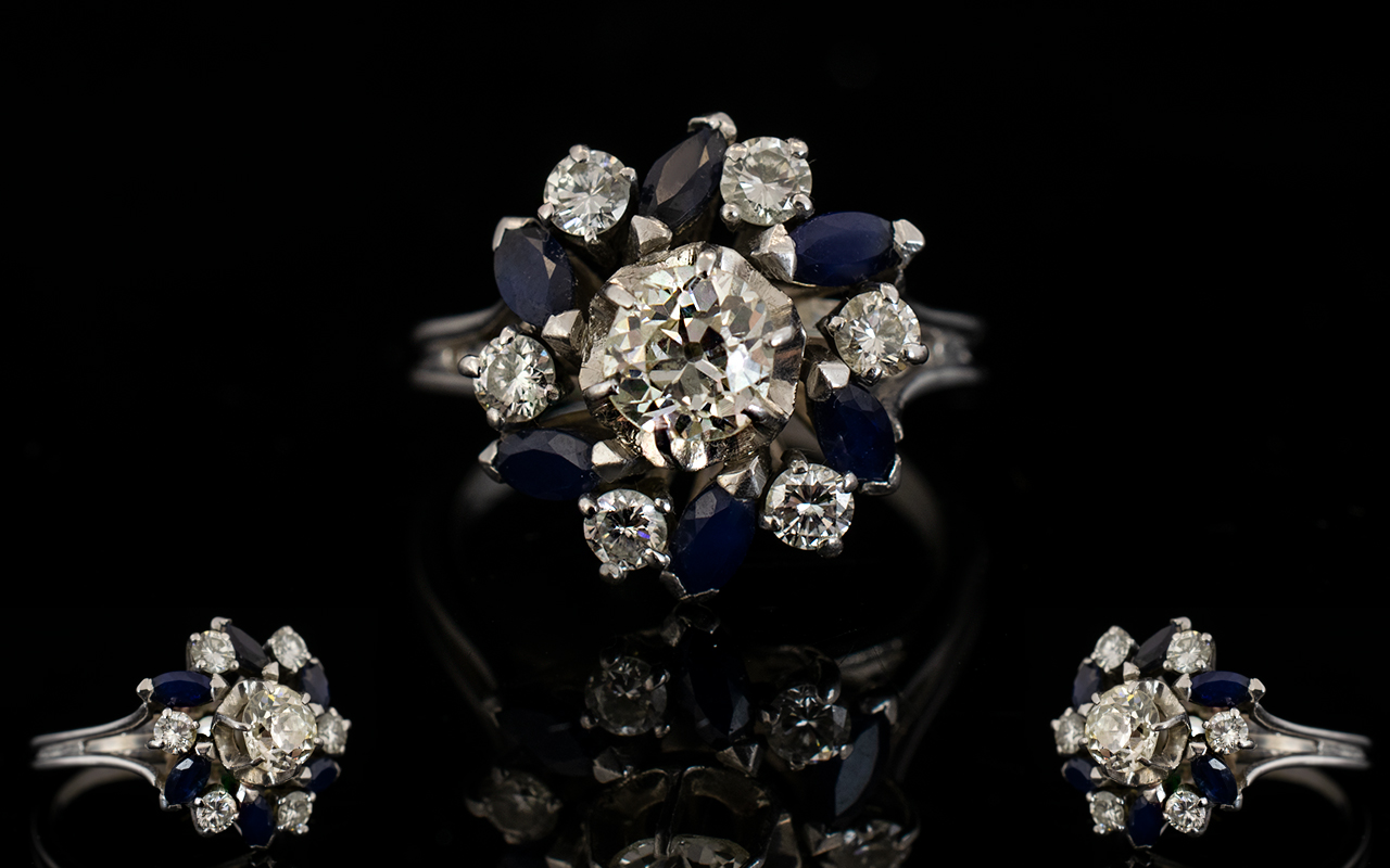 18ct White Gold Diamond And Sapphire Cluster Ring The central diamond surrounded by alternating