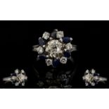 18ct White Gold Diamond And Sapphire Cluster Ring The central diamond surrounded by alternating