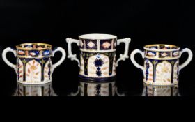 Loving Cups x 3 in the style of Royal Crown Derby, two small size and on larger size, white,