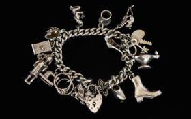 A Silver Curb Bracelet Loaded with 14 Solid Silver Old Charms From The 1950's / 1960's.