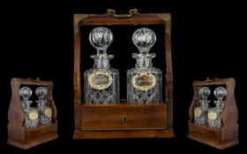 A Cut Glass Tantalus Comprising two square form decanters, each with etched metal labels,