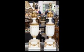 A Pair Of Neoclassical Style Lamp Bases cream and gilt finish of urn form with acanthus terminals,