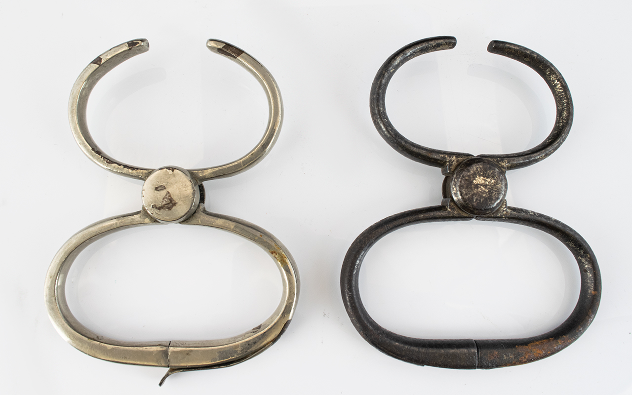 A Pair Of Antique Metal Shackles One Wit