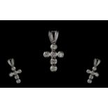 A Small 9ct White Gold Cross Set with 5 round cut diamonds.