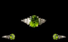 Peridot and Diamond Ballerina Ring, a 2.25ct oval cut peridot, flanked by .