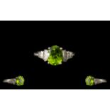 Peridot and Diamond Ballerina Ring, a 2.25ct oval cut peridot, flanked by .