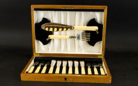 A Cutlery Set In Fitted Box Comprising fish knives and servers with ivorine handles.