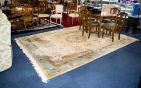 A Large Oriental Wool Rug Cream ground with triple border detail in foliate and Greek key Intarsia.