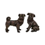 A Pair Of Freestanding Resin Pug Figures Each with yellow glass eyes, one depicted in seated pose,