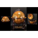 A Reproduction Globe Mini Bar of traditional form, raised on a quatrefoil base with turned supports,