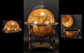 A Reproduction Globe Mini Bar of traditional form, raised on a quatrefoil base with turned supports,