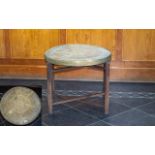 An Egyptian Brass Topped Occasional Table X- frame table with embossed circular top with figural