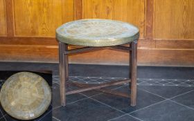 An Egyptian Brass Topped Occasional Table X- frame table with embossed circular top with figural