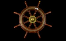 A Reproduction Ships Wheel Of typical form with brass inlay and mounts, diameter 24 inches.