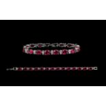 A Contemporary Silver Garnet And CZ Set Tennis Bracelet Of elegant form comprising fourteen oval