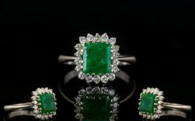 18ct White Gold Attractive Emerald And Diamond Cluster Ring Fully hallmarked, the central step cut