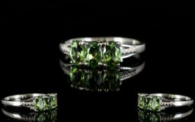 Green Apatite Three Stone Ring, three oval cut natural green apatites, totalling 1.5cts, set in a