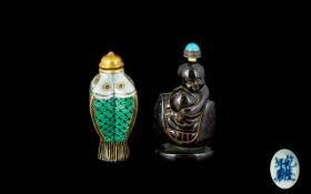 Two Oriental Snuff Bottles One in the form of stylised fish, with domed gilt stopper.