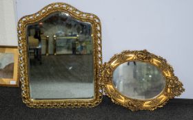 Two Gilt Edged Mirrors with bevelled glass. One in oval form decorated with cherubs, 53 x 48 cm.