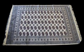 A Large Woven Silk Bokhara Carpet Ornate silk carpet with traditional repeat design with intricate