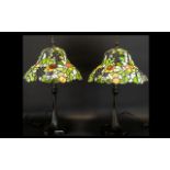 A Pair Of Reproduction Tiffany Style Table Lamps Each raised on black cast metal base with shaped