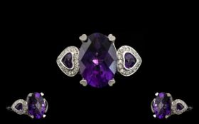 A 14ct White Gold Amethyst And Diamond Cluster Ring Central oval amethyst set between two heart