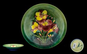 William Moorcroft Signed Tubelined Footed Bowl ' Freesia ' Design on Green Ground. c.1935.